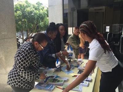 Photo Caption: Staff of the Ministry of Social Development and Family Services distribute brochures on the Ministry's programmes and services during its 2017 World Social Work Day Open House at the Ministry’s CL Financial Head Office. (Photo Courtesy: Ministry of Social Development and Family Services)