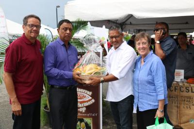 Senator the Honourable Clarence Rambharat, Minister of Agriculture, Land and Fisheries makes a presentation of an all local fruit and vegetable hamper, courtesy NAMDEVCO to His Worship the Mayor of Chaguanas, Alderman Gopaul Boodhan; with Mr. Dennis Ramdeen, Chairman, NAMDEVCO (l); and Food and Agriculture (FAO) Representative Ad Interim for Trinidad and Tobago and Suriname, Dr. Terri Raney (r)