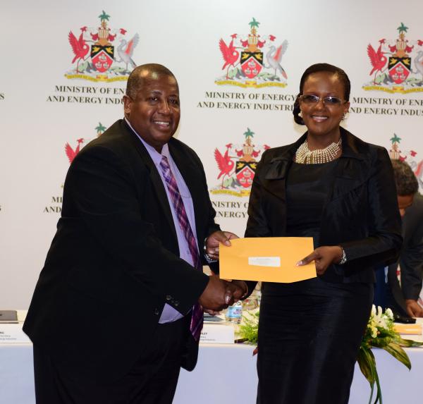 Permanent Secretary, Ministry of Energy and Energy Industries, Mr. Selwyn Lashley presents Vice Chairman, PLCC, Ms. Anita M. Hankey with her Letter of Appointment.