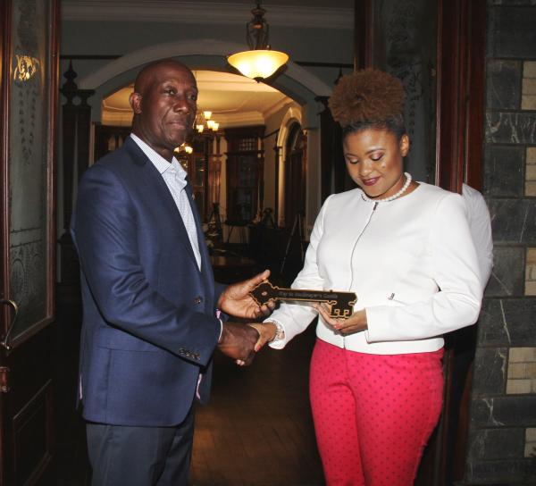 Prime Minister Dr the Honourable Keith Rowley hands the symbolic keys to Minister of Community Development, Culture and the Arts, Dr the Honourable Nyan Gadsby-Dolly