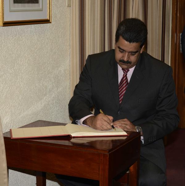 President Maduro signs the guest book shortly after arriving at the President's House to visit Trinbagonian President, Anthony Carmona.